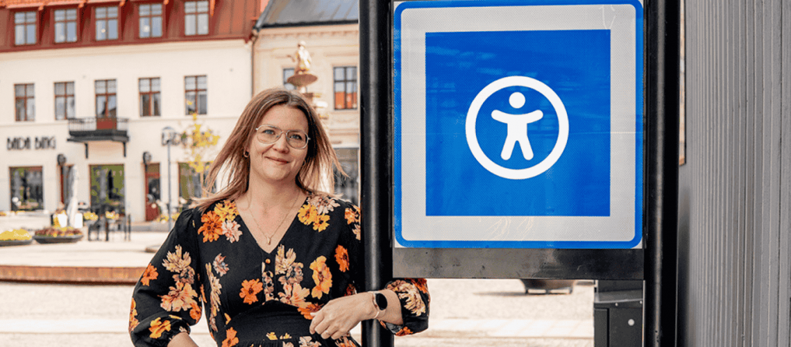 En bild på en UX-designer som vid sidan av en skylt med en tillgänglighetssymbol